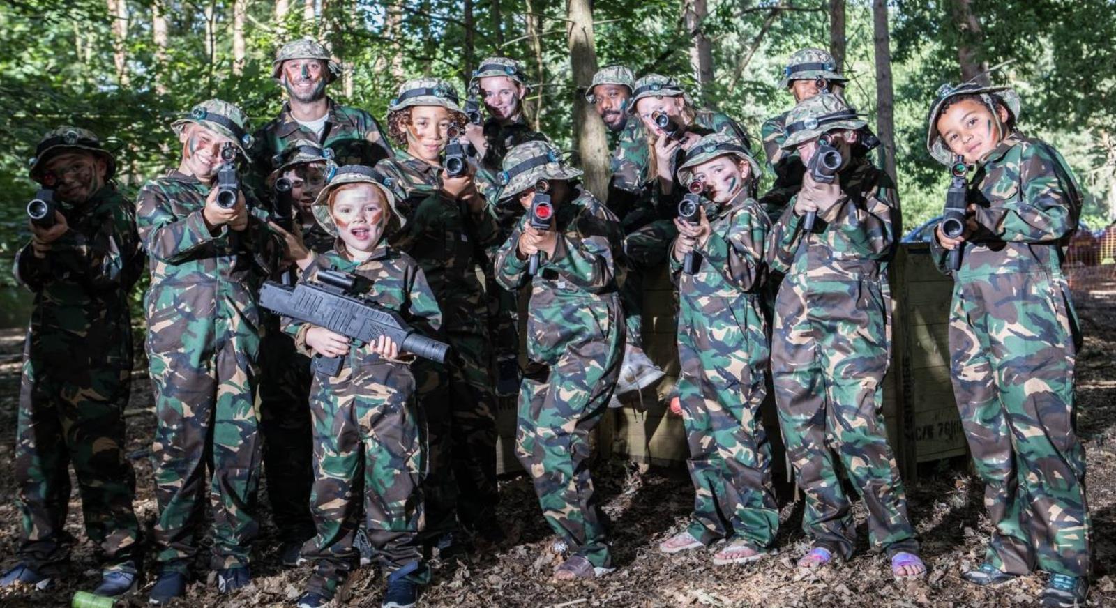 Adults and children in camouflage kit ready to take part in activities