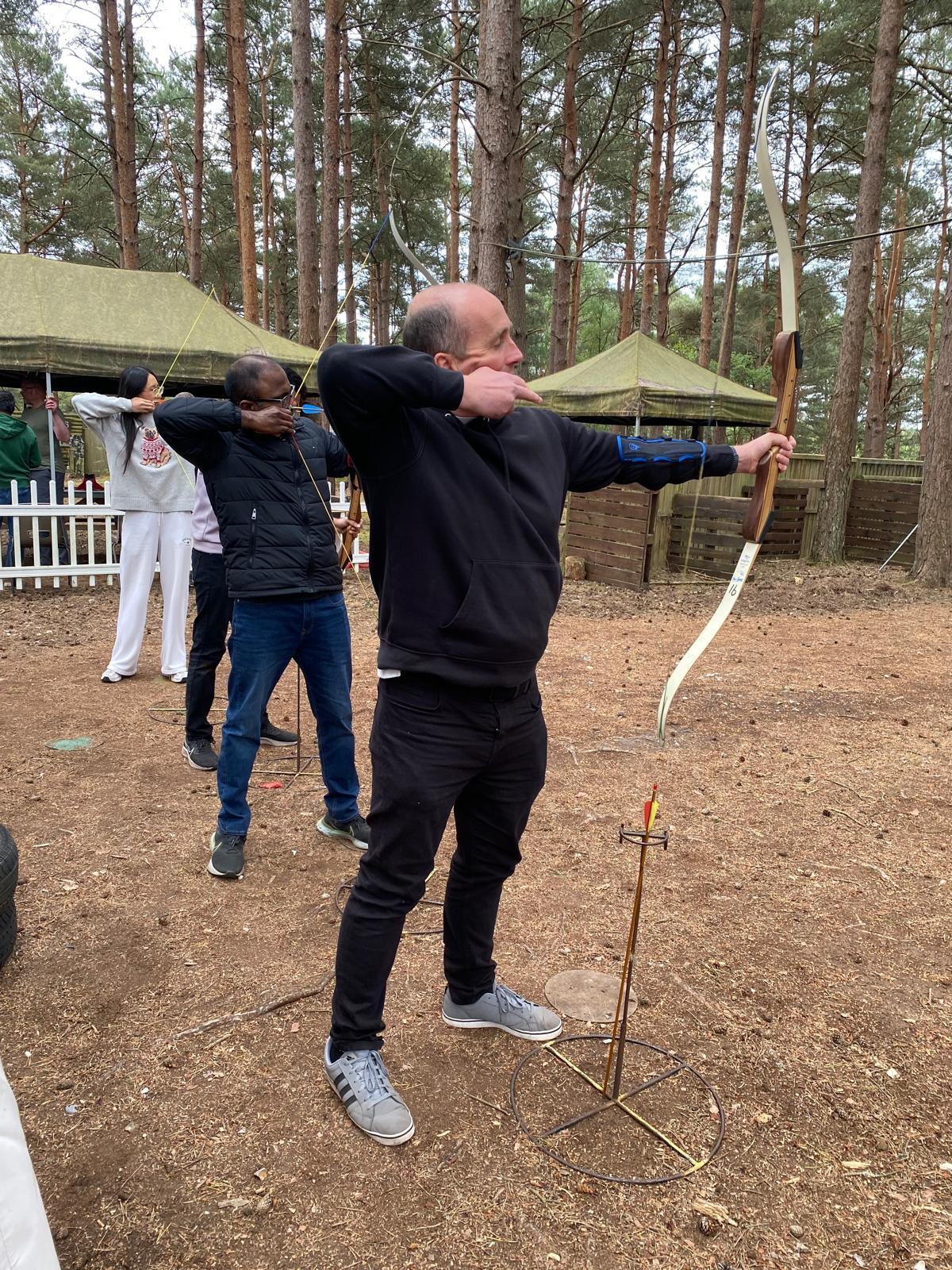 Archer at full draw with a recurve bow during a session on the woodland range