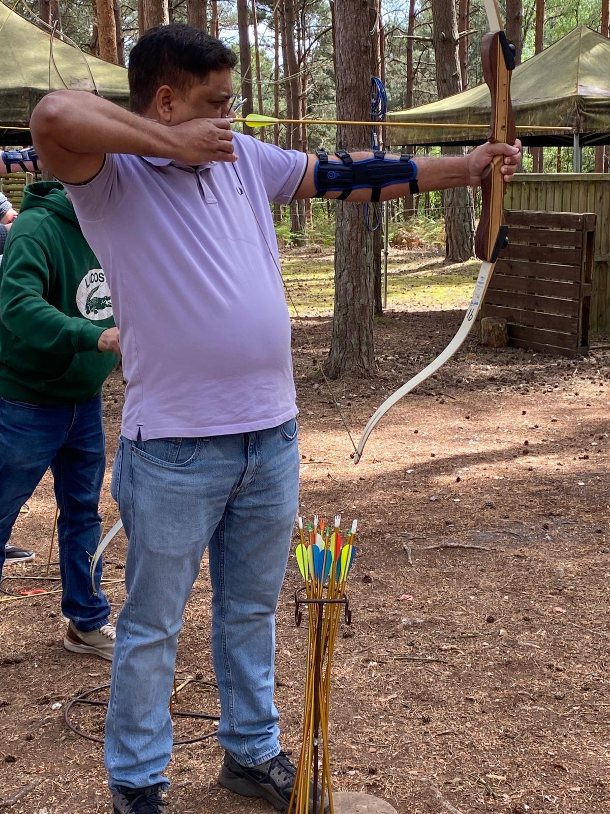 Young archer at full draw aiming down the range